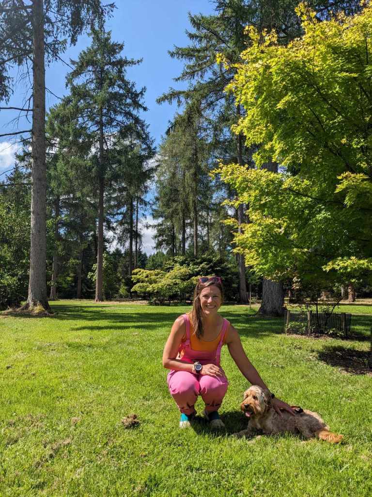 Jenn & Finch sitting infront of towering trees.
